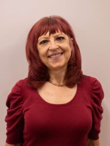 Wendy Gardner, an Employment Consultant at Rise, wears a red top and smiles for the camera.