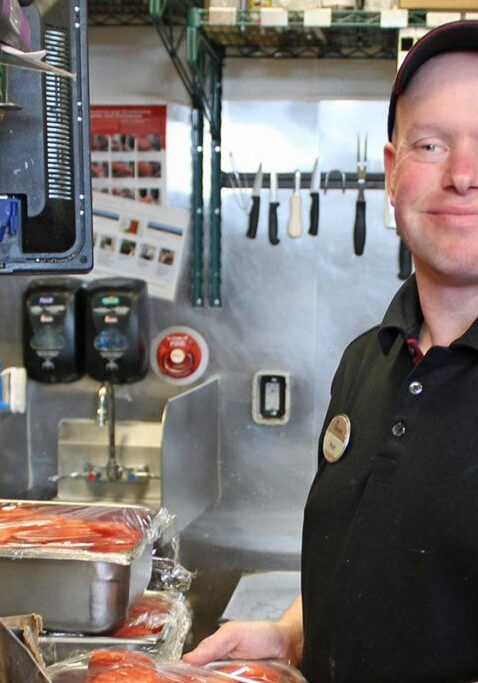 armhs guy working in restaurant in hat with name tag