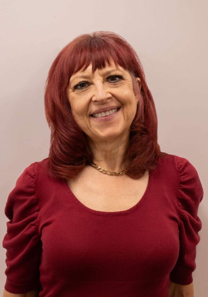 Wendy Gardner, an Employment Consultant at Rise, wears a red top and smiles for the camera.