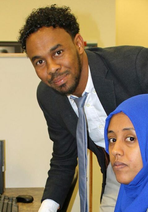 individuals with disabilities man and woman smiling by computer