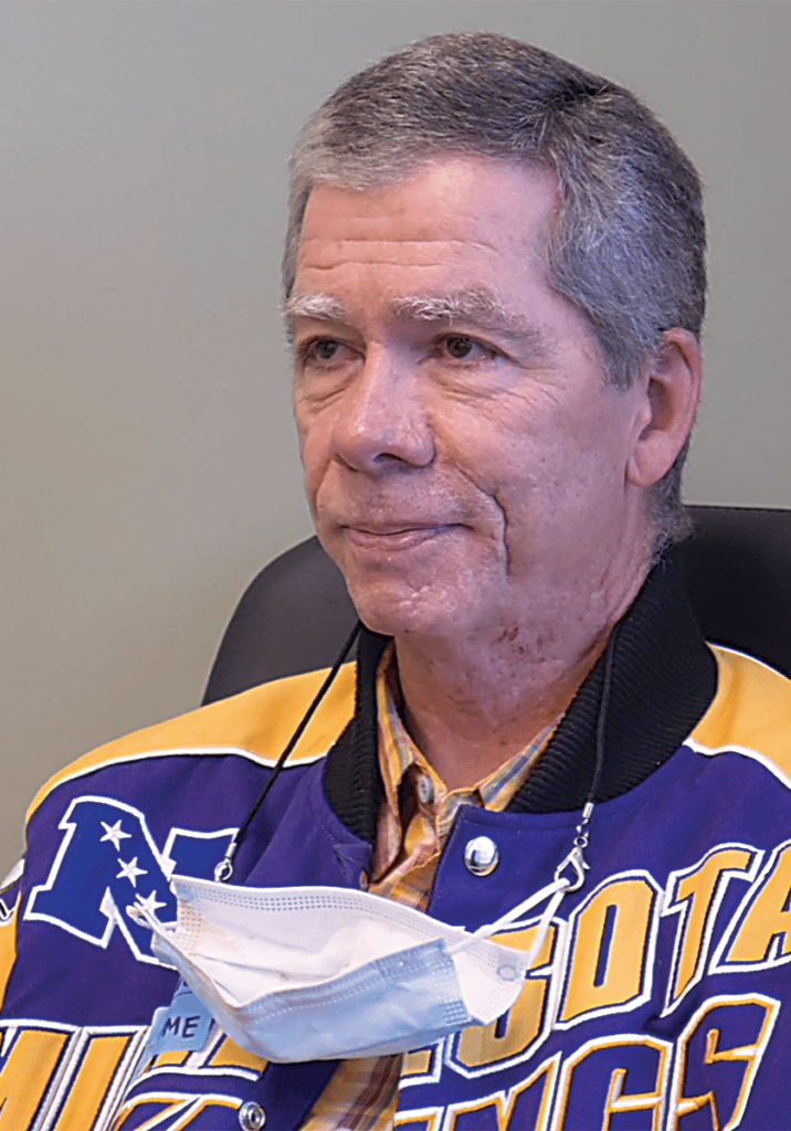 John Deneau wearing a purple and gold Minnesota Vikings jacket.