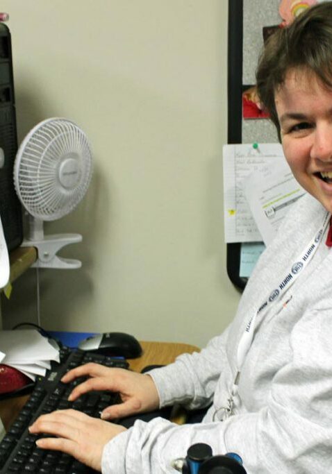 employment services lady smiling working on computer and keyboard