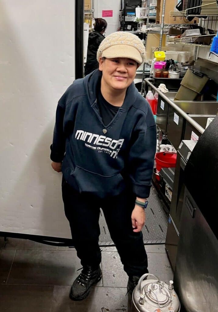 Mata smiles in front of the sinks at her job at Starbucks.