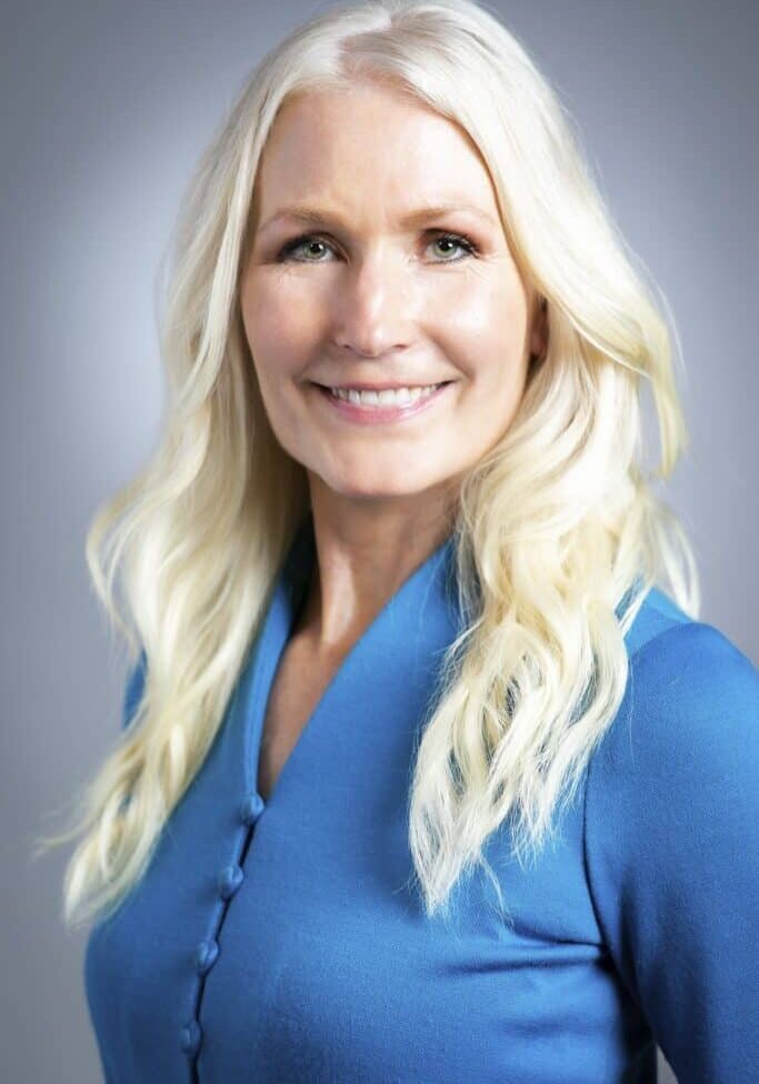 professional headshot of blonde woman in blue button up shirt