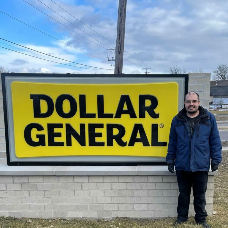 Tristan stands in front of a Dollar General Store sign.