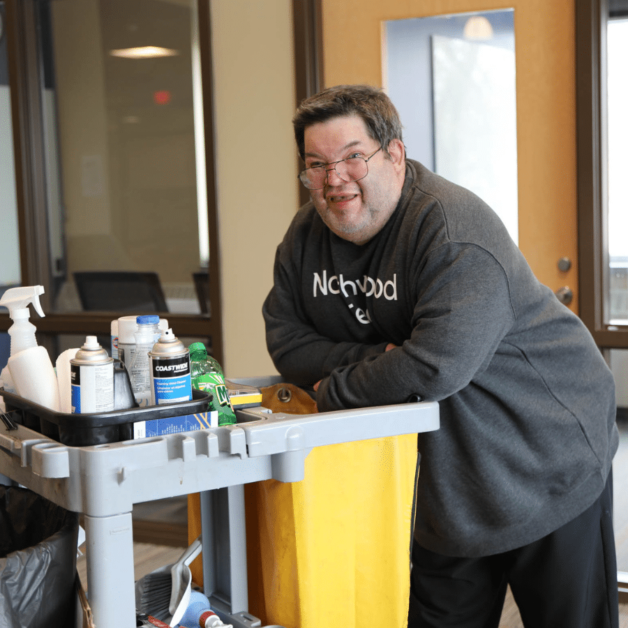 A Rise worker stands with their janitorial cart.