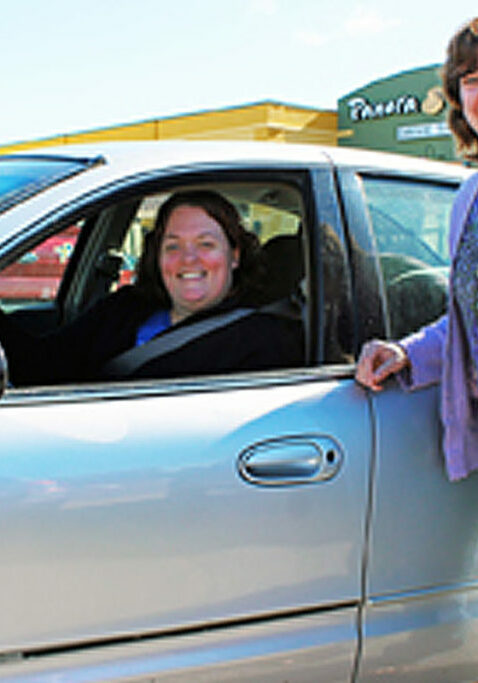 caring member of the community ladies smiling by car